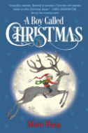 Image for "A Boy Called Christmas" book cover with a blue background and a huge glowing moon in the center.  There is a juvenile boy wearing a Santa-like costume riding a grey reindeer. 
