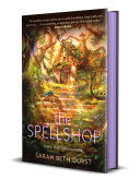 "The Spellshop" book cover showing a magical cottage in the background with steps going through a fantasy woods.  A small kitten with wings is lying on the steps, a small kitten with wings. 