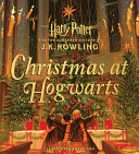 Image for "Christmas at Hogwarts" book cover with 3 young kids in with robes and scarves on in the center in awe of the Hogwart's Christmas scene before them - 