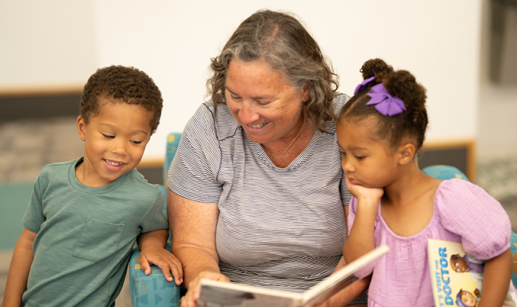 Woman reading to two children in the library