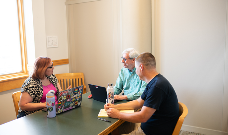 Group of three adults using a study room